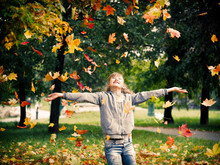 Young Beautiful And Very Happy Girl Playing With Autumn Leaves In The Park. Autumn Leaf Fall