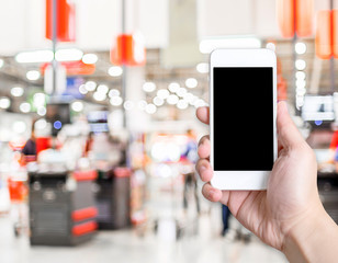 Aufkleber - Hand holding mobile phone with blur customer at supermarket stor