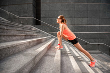 Young Sports Woman Stretching Legs On The Stairs In The Modern City. Healthy Lifestyle In The Big City.