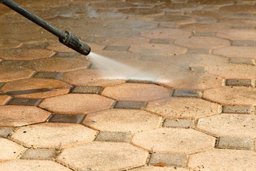 Cleaning concrete block floor by high pressure water jet.