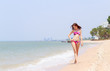 © chaiviewfinder - Beautiful women in bikinis strolling happily along the beach.