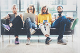 Fototapeta  - Group Adult Hipsters Friends Sitting Sofa Using Modern Gadgets.Business Startup Friendship Teamwork Concept.Creative People Working Together Marketing Project.Coworking Process Office Studio.Blurred.