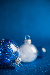 Wall Mural - white and blue christmas ornaments on dark blue glitter background with space for text. merry christ