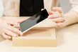 © golubovy - Unrecognizable woman getting new phone out of box. Female hands holding modern smartphone with blank screen . Online shopping, technology, recent gadget concept
