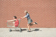© Laszlo - two female having fun with a shopping cart at the mall parking lot
