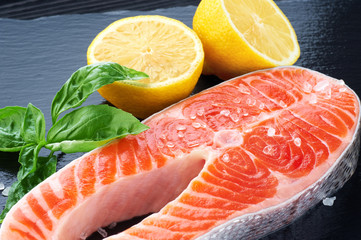 Wall Mural - Fresh salmon with lemon and basil on a dark background