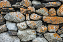Stone Boulders Covered With Orange Lichen.