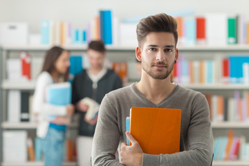 Wall Mural - Confident student posing in the library