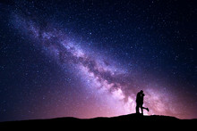 Milky Way. Night Landscape With Silhouettes Of Hugging And Kissing Man And Woman On The Mountain. Colorful Sky With Stars. Silhouette Of Lovers. Couple, Relationship. Milky Way With People. Universe