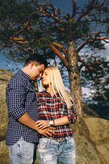 Young beautiful couple in jeans and shirts for a walk in the mou