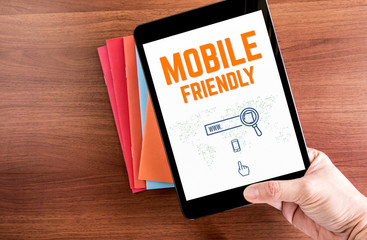 Poster - Top view of hand holding tablet with mobile friendly word and ic