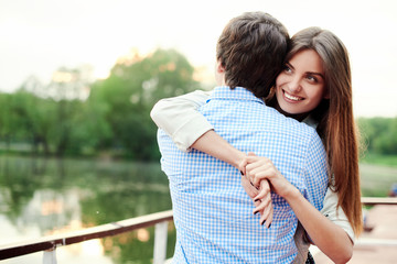 Young beautiful and happy girl embracing her boyfriend