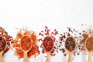 Wall Mural - Spices in spoons on a wooden background