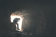 sad man praying god in a dark cavern