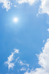 Wall Mural - blue sky with clouds and sun reflection. looking up view