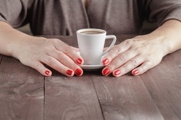 Wall Mural - Close up portrait of female hands holding cup of coffee