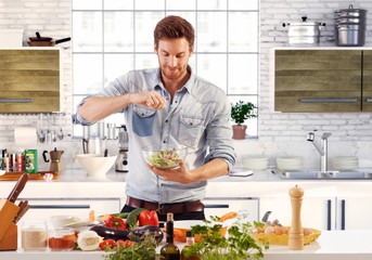 Poster - Handsome man preparing salad in kitchen