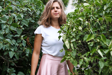 A young woman in the bushes.