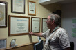 © Kzenon Premium - Senior carpentry master showing the wall of fame in his workshop