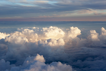 Wall Mural - Aerial view of thick clouds over the land, the landscape. The texture of the scenic sky during sunset.