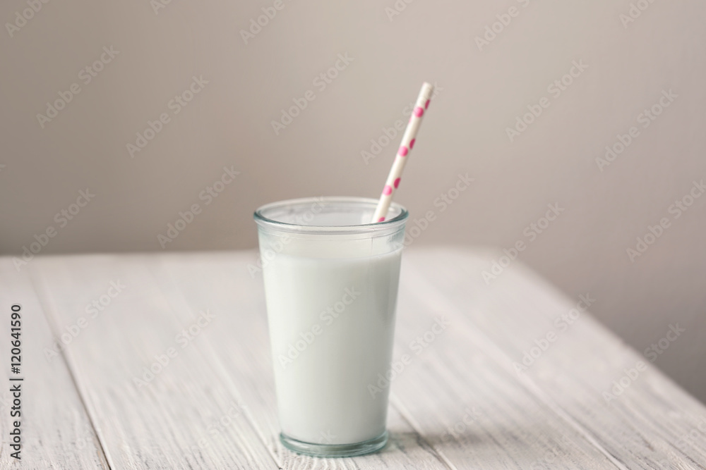 Glass of fresh milk on white wooden table