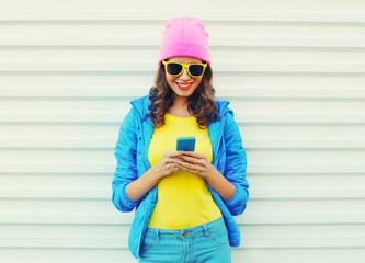 Wall Mural - fashion happy cool smiling girl using smartphone in colorful clo