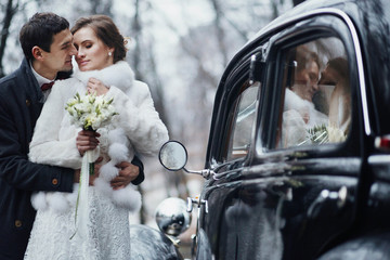 beautiful couple standing near a wedding cortege