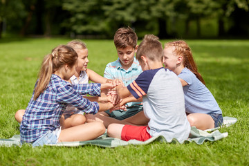 Poster - group of happy kids putting hands together