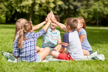 Poster - group of happy kids making high five outdoors