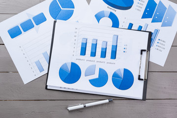 Financial paper charts and graphs on the table.