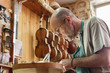 © Kzenon Premium - Violin maker being absorbed by work on a new instrument