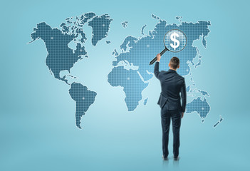 Wall Mural - Back view of a businessman looking at world map through magnifying glass and seeing dollar sigh