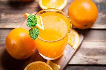 Wall Mural - fresh fruits orange juice in glass on wood,selective focus on gl