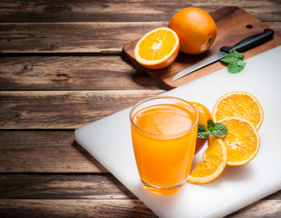 Wall Mural - fresh fruits orange juice in glass on wood,selective focus on gl