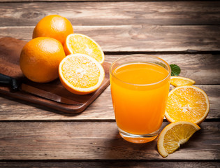 Wall Mural - fresh fruits orange juice in glass on wood,selective focus on gl