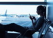 © kieferpix - Woman traveler using smartphone at airport.
