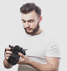 young bearded photographer taking pictures with digital camera.