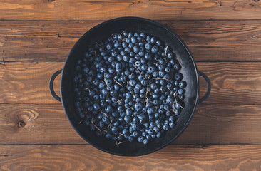 Wall Mural - Blueberries on vintage wooden black background top view, healthy food on dark table mockup, berry for smoothie isolated on rustic country board, fresh nutrition closeup, copy space for text design