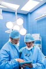 Poster - Surgeons discussing over digital tablet in operation room