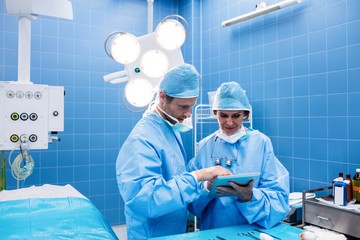Poster - Surgeons discussing over digital tablet in operation room