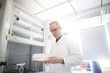 © Connect Images - Male meteorologist examining test tube tray in weather station laboratory