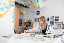 Female Designer Preparing Mixed Media Design In Printing Press Studio