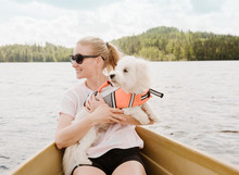 Woman Holding Coton De Tulear Dog In Boat, Orivesi, Finland