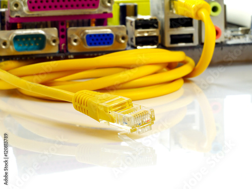 Fotografía yellow twisted pair ethernet network cable connected to dismounted motherboard,