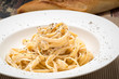 Fettuccine Alfredo classic Italian Pasta on a dark wood table..
