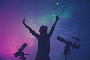 Wall Mural - girl enjoying starry skies with telescopes beside her.
