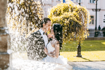 Wall Mural - wedding couple kiss near fountain water