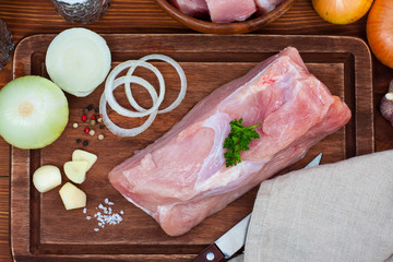 Raw fresh dietary meat turkey breast fillet on a wooden cutting board, top view