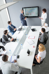 Workers group at meeting table listen manager