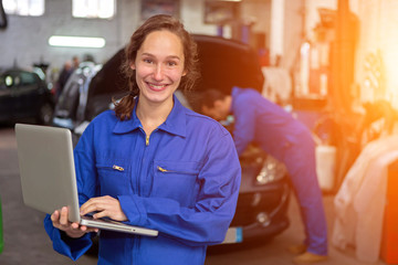 Wall Mural - Young attractive woman mechanic working at the garage